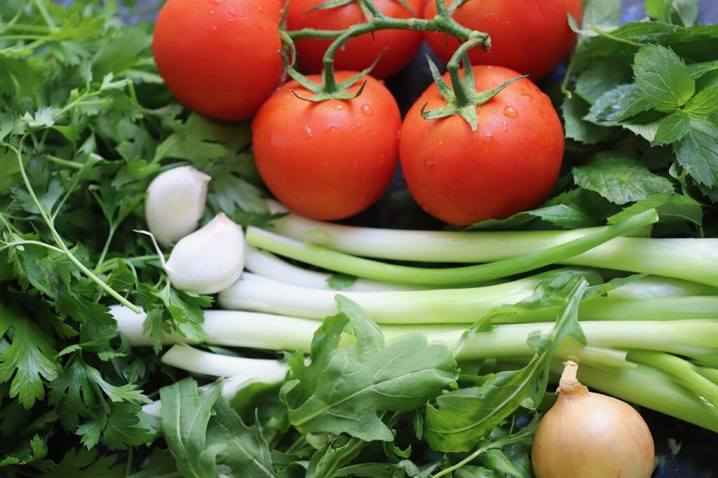 Image of fresh tomatoes, onions, greens, and other vegetables.